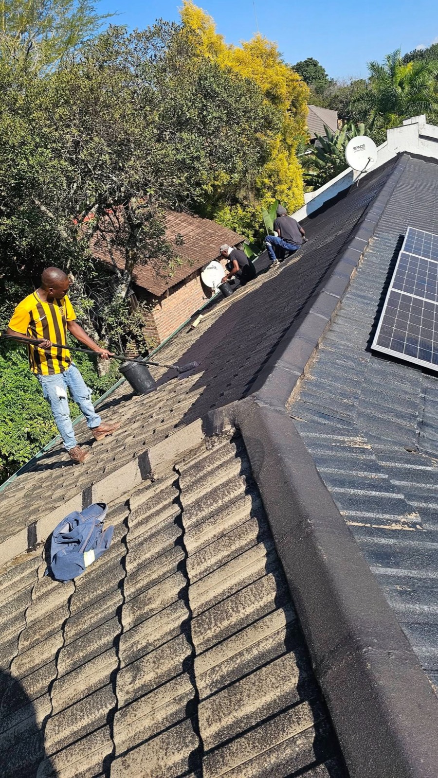 Roof coating being applied to a tiled roof
